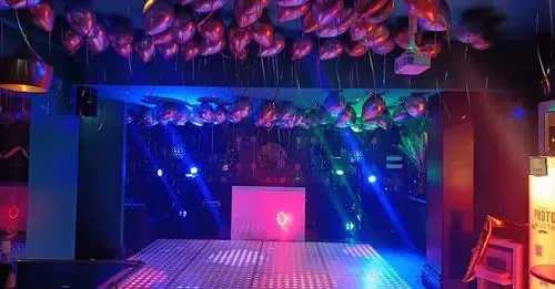 Feestzaal met led-dansvloer, booth en ballonnen